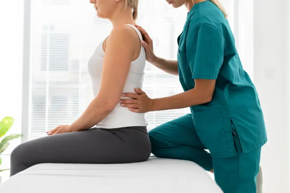 Physiotherapeutin untersucht die Schulter einer Patientin